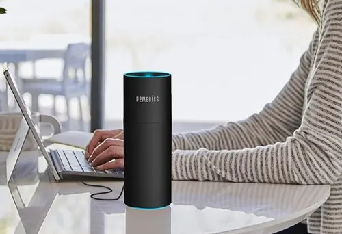 Person working on laptop next to Homedics mini humidifier